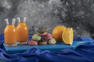 färgglada söta munkar med glasburkar juice och skivad frukt