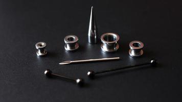 uppsättning piercingverktyg på en mörk bakgrund foto