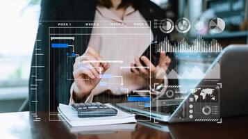 affärsman hand projekt chef arbetssätt och uppdatering uppgifter och gantt Diagram schemaläggning virtuell diagram.med smart telefon, läsplatta och bärbar dator i kontor. foto