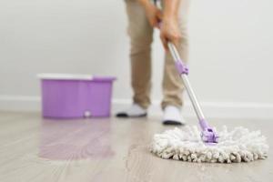 anställda använda sig av mopp torkdukar till rena de golv inuti de hus. foto