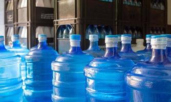 de blå vatten gallon som innehåller dricka vatten har varit sluten med en plast täta i de dricka vatten växt till vänta för leverans foto
