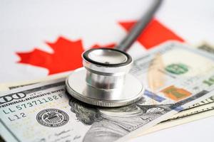 svart stetoskop med oss dollar sedlar kanada flagga bakgrund, företag och finansiera begrepp. foto
