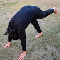 ung indisk kvinna praktiserande yoga utomhus- i en parkera. skön flicka öva grundläggande yoga utgör. stillhet och koppla av, kvinna lycka. grundläggande yoga poser utomhus- foto