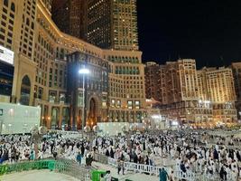 mecka, saudi Arabien, Mars 2023 - en stor siffra av umrah pilgrimer i främre av de klocka torn i masjid al haram. foto