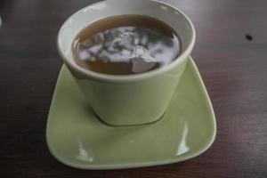 stänga upp Foto av varm ingefära traditionell dryck av indonesien med grön kopp. de Foto är lämplig till använda sig av för dryck bakgrund och matälskare posta innehåll.
