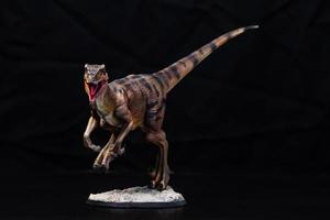 de velociraptor dinosaurie i de mörk foto