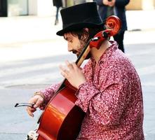 bologna, Italien, april 16, 2022, gata artist, spelar cello i de historisk stadens centrum distrikt av bologna. busking på gata begrepp. foto