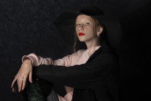 en Tonårs flicka i en svart hatt klädd upp för de Semester av halloween. foto