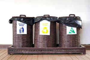3 bambu vävning soptunnor med lock för allmän avfall, återvinningsbar avfall och organisk avfall. till separat avfall typer innan dumpning, återvinning eller använder sig av biokompost. foto