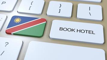 bok hotell i namibia med hemsida uppkopplad. knapp på dator tangentbord. resa begrepp 3d animation. bok hotell text och nationell flagga. 3d illustration foto