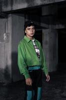 ett asiatisk man bär en grön jacka och svart mössa foto