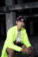 ett asiatisk man i en grön jacka Framställ och Sammanträde mycket vardagligt foto