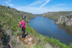 kvinna vandrare väger de flod i de dal foto