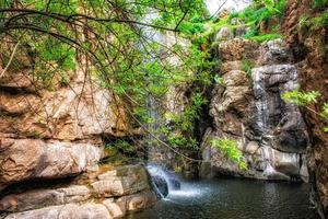 vatten cascading ner en sten ansikte foto