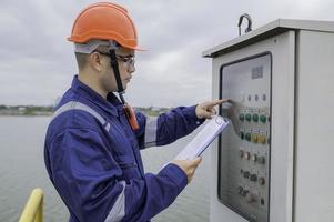 vatten växt underhåll tekniker, mekanisk ingenjörer kolla upp de kontrollera systemet på de vatten behandling växt. foto