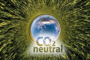 co2 neutral text begrepp bild mot blå liten planet i grön gräs bakgrund foto