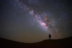 Vintergatan med en man som står och tittar på tjäröknen, Jaisalmer, Indien foto
