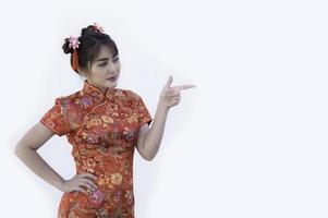 porträtt vacker asiatisk kvinna i cheongsam klänning, thailändska människor, gott kinesiskt nyårs koncept, glad asiatisk dam i traditionell kinesisk klänning foto