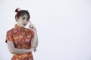 porträtt skön asiatisk kvinna i Cheongsam klänning, thailand människor, glada kinesisk ny år koncept, glad asiatisk lady i kinesisk traditionell klänning foto