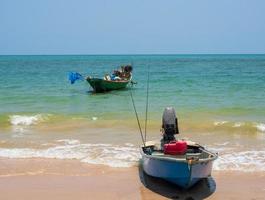 landskap se vy liten fiskebåt trä gammal parkerad kust havet. efter fiske av fiskare i liten by är det litet lokalt fiske. blå himmel, vita moln, klart väder, phala beach, rayong foto