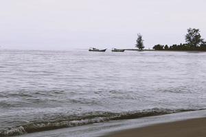 skön tropisk strand med vit sand, turkos hav mot blå himmel med moln på solig sommar dag. landskap bakgrund foto