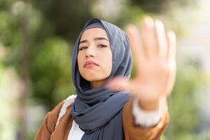 allvarlig muslim kvinna gestikulerar sluta med de hand foto