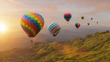 färgrik varm luft ballonger flygande ovan berg på soluppgång himmel bakgrund. resa naturlig bakgrund. foto