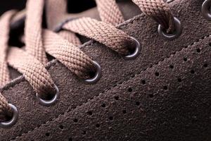 del av en mocka känga med snören. en fragment av brun skor. en bit av sneaker. foto