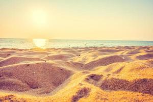 vackert hav och sand med solnedgång foto