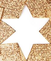 pesach firande begrepp - jewish Semester pesach. vikta matzah i de form av stjärna av David isolerat på vit bakgrund. kopia Plats för text foto