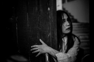 porträtt av asiatisk kvinna göra upp spöke ansikte med blod, skräck scen, skrämmande bakgrund, halloween affisch, thailand människor, spöke bio affisch foto