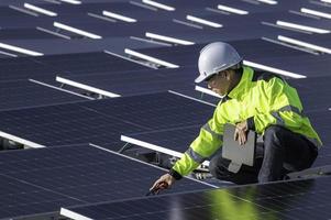 asiatisk ingenjör arbetssätt på flytande sol- kraft anläggning, förnybar energi, tekniker och investerare sol- paneler kontroll de paneler på sol- energi installation foto