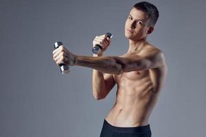 sportig man uppblåst torso hantlar i hand träna kondition foto