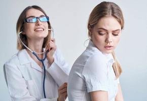 de patient vände sig henne tillbaka till de läkare i en medicinsk klänning med en stetoskop foto