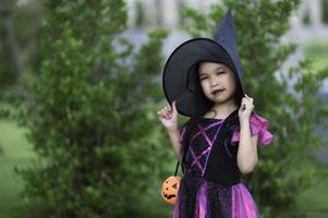 asiatisk söt kvinna unge ha på sig häxa kostym med pumpa, halloween festival begrepp foto