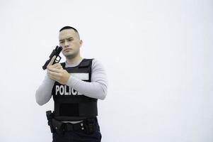 porträtt av polis håll pistol i hand på vit bakgrund, stilig asiatisk polis foto