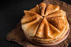 bunt med läckra pannkakor på en svart bakgrund foto