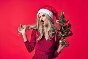emotionell kvinna klädd som santa jul träd leksaker rosa bakgrund foto