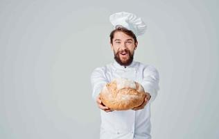 kock med bröd i hans händer mat förberedelse restaurang yrkesverksamma foto