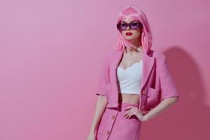 ung positiv kvinna rosa kostym solglasögon Framställ rosa bakgrund oförändrad foto