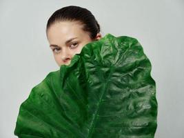 ung kvinna naturlig se grön blad handflatan träd rena hud modell foto