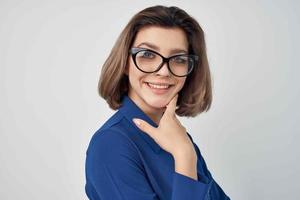 företag kvinna i blå skjorta bär glamour glasögon Framställ ljus bakgrund foto
