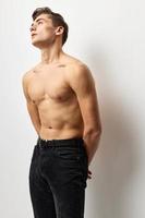 ung man med en naken torso ser upp Framställ självförtroende foto