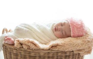 nyfött behandla som ett barn sova i en korg på vit bakgrund