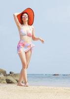 asiatisk kvinna kopplar av på sommarsemester på stranden