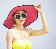 asiatisk kvinna kopplar av på sommarsemester på stranden foto