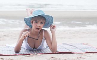 kvinna som sitter på stranden lyckligt