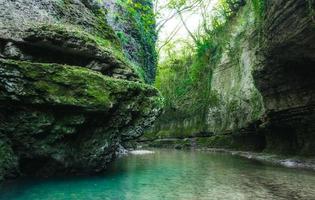 blå flodvatten och grön mossa på stenar foto
