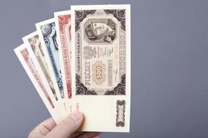 gammal putsa zloty i de hand på en grå bakgrund foto