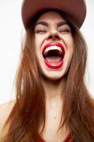 kvinna med en keps glädje känslor öppen mun stängd ögon på henne huvud röd klänning foto